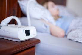 An image of a woman utilizing a CPAP machine for her sleep apnea 