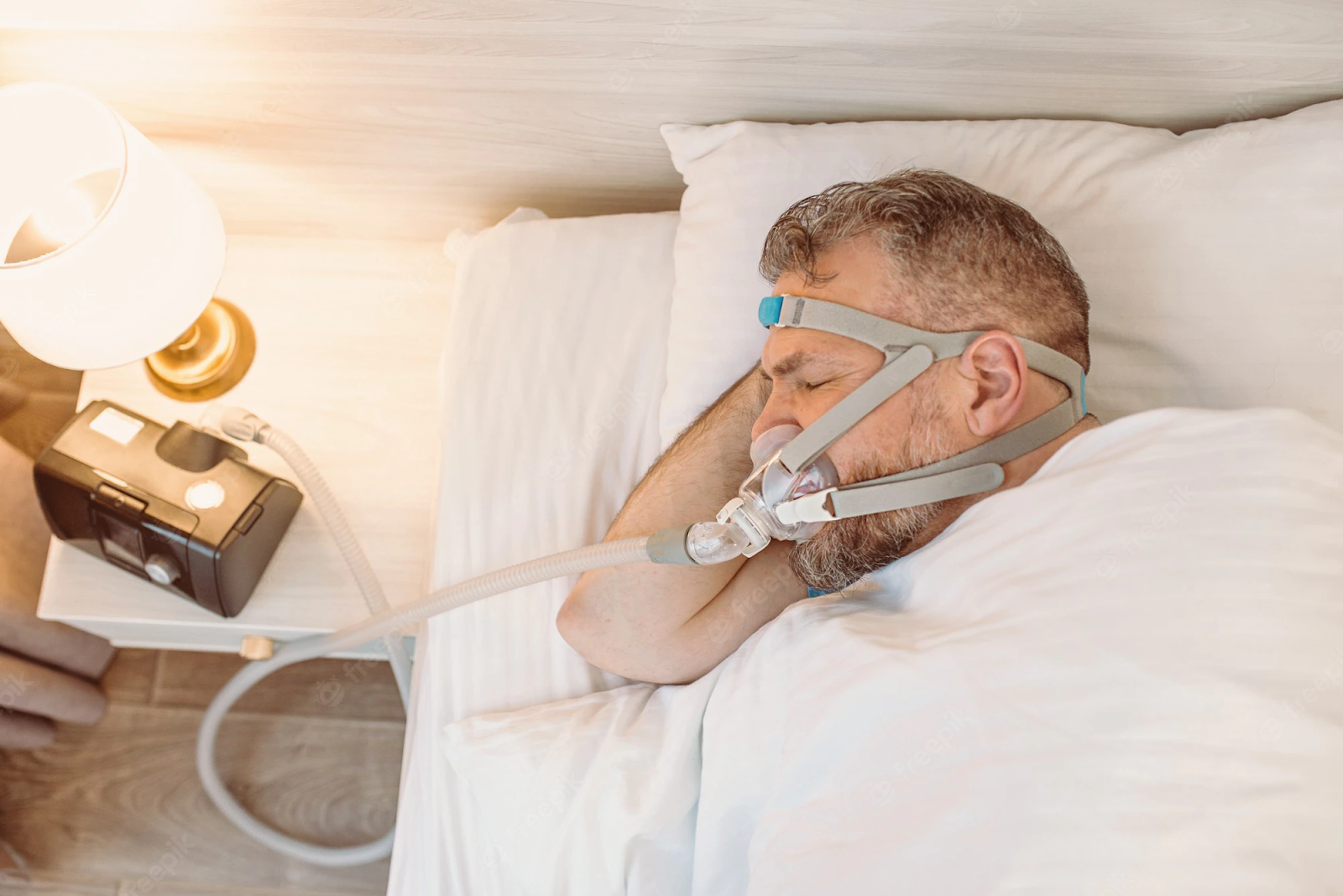 A man using CPAP machine to treat his sleep apnea