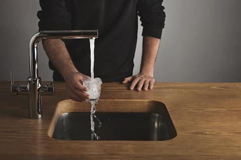 A person fills the cup with tap water.