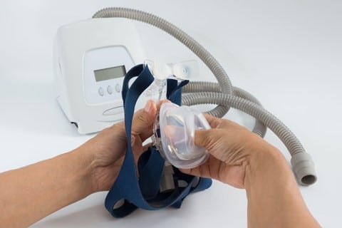 A man`s hand cleaning a CPAP machine