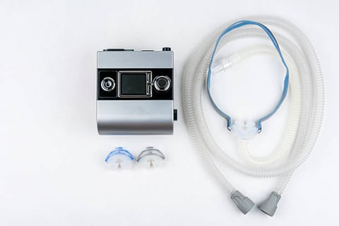 A CPAP machine, complete with hose and nose mask. 