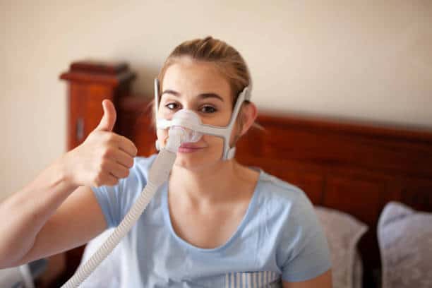 A picture of a happy woman using her CPAP