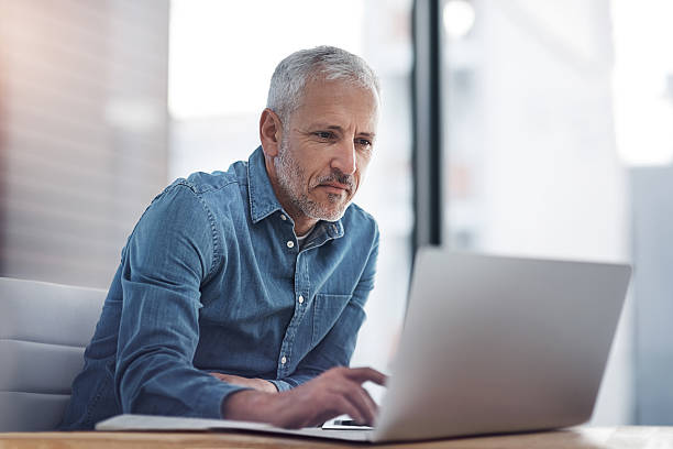 Mature businessman working on a laptop in an office