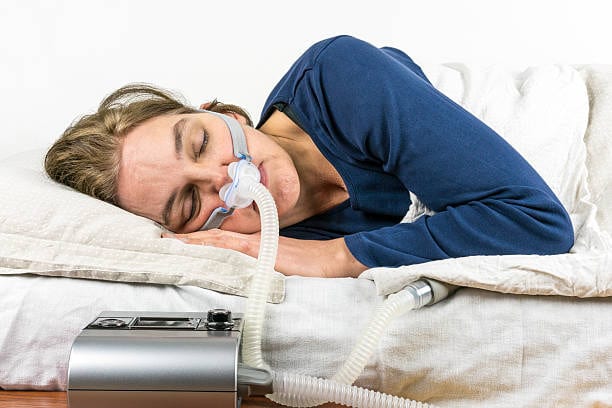 A photo of a woman utilizing CPAP machine
