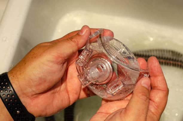 CPAP Mask equipment in sink for cleaning with soap 