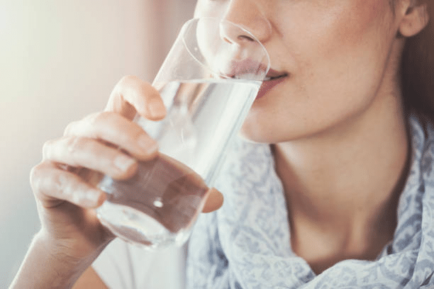 A photo of a woman drinking a glass of water