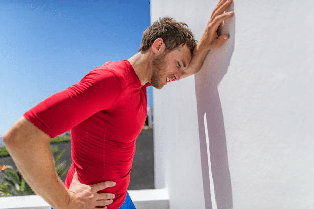 Athlete man leaning on the wall and his breathing hard