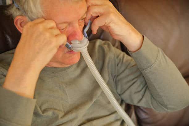 A senior man fitting his CPAP mask