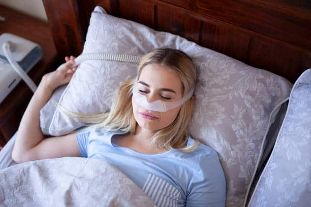A girl sleeping using one of the best CPAP machines
